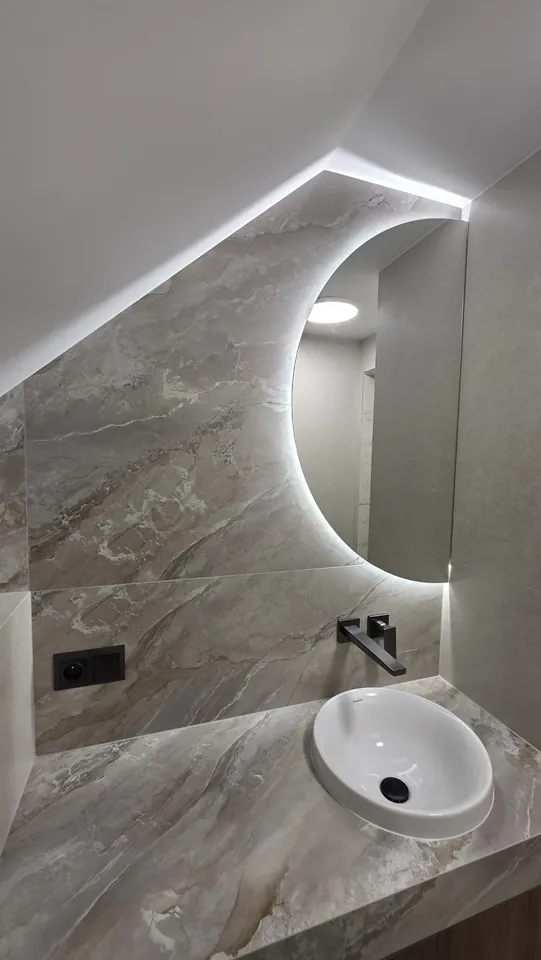Detal lustra LED i strefy umywalki w małym WC